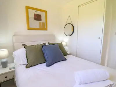 a bedroom with a white bed and a mirror at Hill View in Tywyn