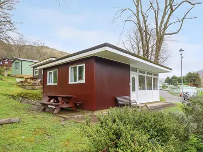 a red and white tiny house with a picnic table at Hill View in Tywyn