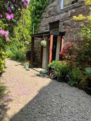a garden entrance to a stone building with plants at Swn y nant Barmouth road A496 Llanelltyd in Penmaenpool