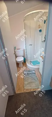 a bathroom with a shower with white writing on the wall at Amelia 615 Barmouth in Talybont