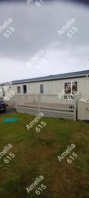 a house with a fence and a field of grass at Amelia 615 Barmouth in Talybont