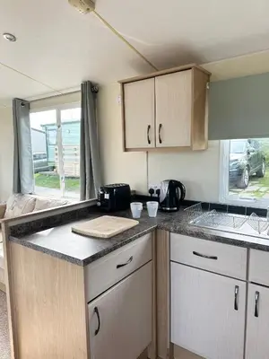 a kitchen with wooden cabinets and a counter top at MoonStone in Aberystwyth