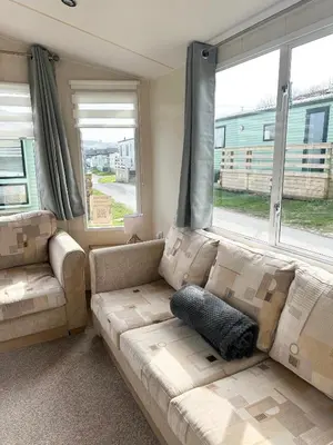 a living room with a couch and a large window at MoonStone in Aberystwyth