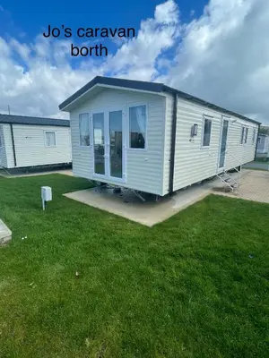 a tiny house is sitting on a lawn at Caravan by the beach in Borth