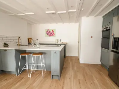 a kitchen with a counter and stools in it at Osborne House in Rhayader