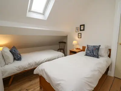 two beds in a room with a window at Osborne House in Rhayader