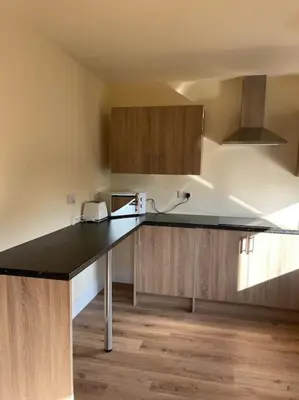 a kitchen with a black counter top and wooden cabinets at Weston pools Lodge with 6 Bedrooms in Oswestry