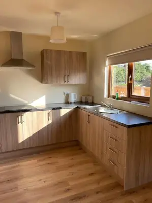 a kitchen with wooden cabinets and a sink and a window at Weston pools Lodge with 6 Bedrooms in Oswestry