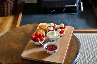 a tray with three desserts and two bowls of ice cream and strawberries at Finest Retreats - Hermon Bach in Dolgellau
