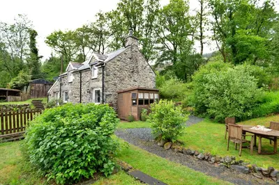 an old stone house in the middle of a garden at Finest Retreats - Hermon Bach in Dolgellau