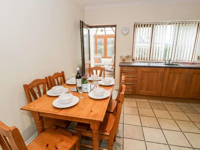 a dining room with a wooden table and chairs at Tremyfron in Bala