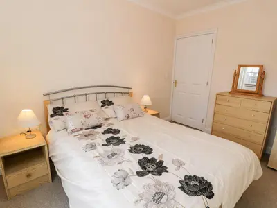 a bedroom with a white bed with flowers on it at Tremyfron in Bala