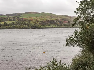 a large body of water with hills in the background at Tremyfron in Bala