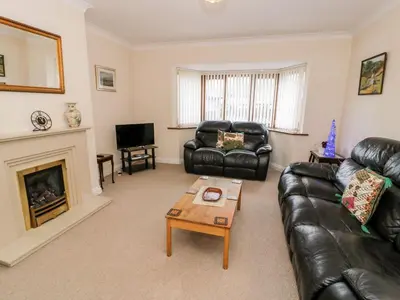 a living room with black leather furniture and a fireplace at Tremyfron in Bala