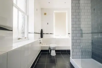 a white bathroom with a toilet and a window at White Lion Royal Hotel in Bala
