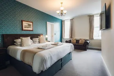 a bedroom with a large bed and a couch at White Lion Royal Hotel in Bala