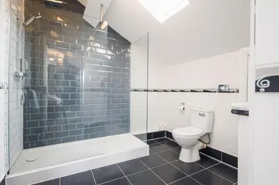 a bathroom with a tub and a toilet and a shower at White Lion Royal Hotel in Bala