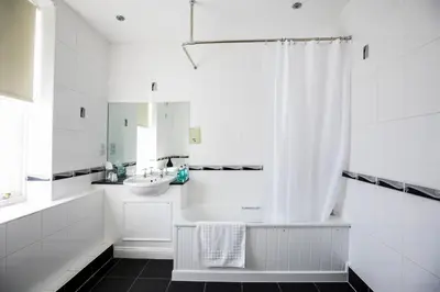 a white bathroom with a sink and a shower at White Lion Royal Hotel in Bala