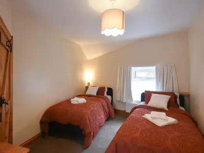 a room with two beds and a window at Llys Dedwydd in Dolgellau