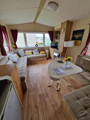 a living room with a couch and a table at Discover Serenity in Our 3-Bed Static Caravan at Clarach Bay Holiday Village! in Aberystwyth