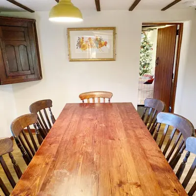 a dining room with a wooden table and chairs at Llynhillyn Cottage in Presteigne