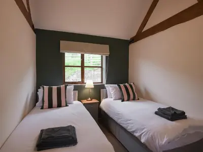 two twin beds in a room with a window at Uk46557 - Caradoc in Church Stretton