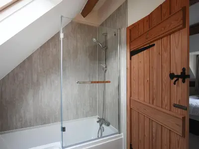 a shower with a glass door next to a tub at Uk46557 - Caradoc in Church Stretton