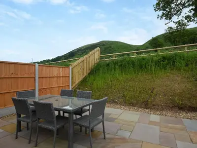 a patio with a table and chairs and a fence at Uk46557 - Caradoc in Church Stretton