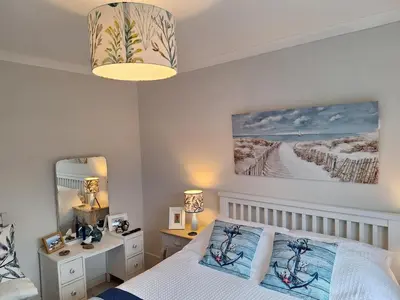 a bedroom with a bed and a desk and a mirror at Brynarfor near Aberaeron in Llanon