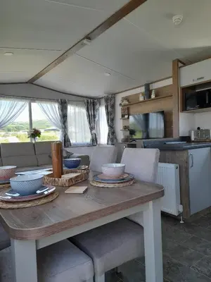 a table with bowls and plates on it in a kitchen at Visma Caravan in Llanddwywe