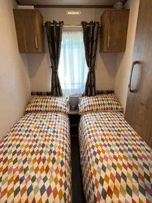 a small room with two beds in a caravan at Visma Caravan in Llanddwywe