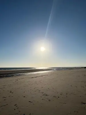 a view of the beach with the sun in the sky at Visma Caravan in Llanddwywe