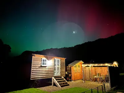 a cabin with a table in front of it at night at Cwt Bugail Aeron in Aberaeron