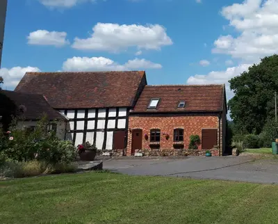an old brick building with two roofs at Granary Cottage a Shropshire haven in Church Stretton