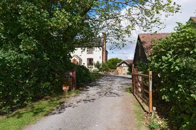 a dirt road leading to a white house at Granary Cottage a Shropshire haven in Church Stretton