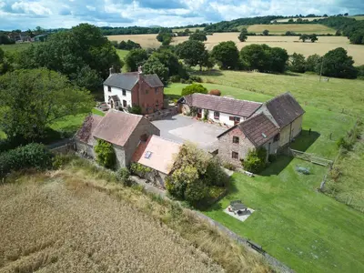 an aerial view of an old house in a field at Granary Cottage a Shropshire haven in Church Stretton