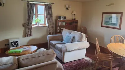a living room with a couch and a chair and a table at Granary Cottage a Shropshire haven in Church Stretton
