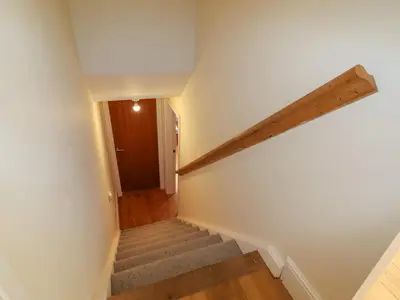 a hallway with stairs and a wooden door at Bryn Golau in Llangollen