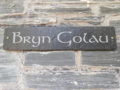 a sign on the side of a brick wall at Bryn Golau in Llangollen