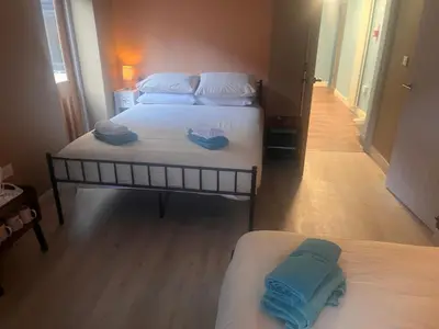 two beds in a small room with blue towels on them at Tumbledown Hotel in Shrewsbury