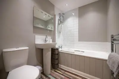 a bathroom with a toilet and a sink and a tub at Modern Sea View Apartment in Aberdyfi