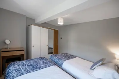 a bedroom with a bed and a dresser and a mirror at Modern Sea View Apartment in Aberdyfi