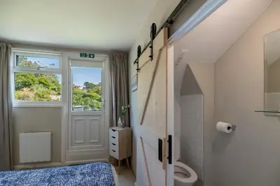 a bathroom with a toilet and a window at Modern Sea View Apartment in Aberdyfi