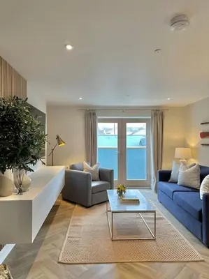 a living room with two blue couches and a table at Tobias Apartment, 2 Bedroom, Aberaeron in Aberaeron