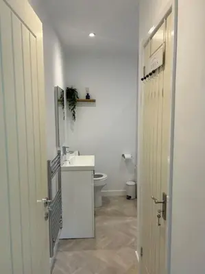 a white bathroom with a sink and a toilet at Kimberly House in Arthog