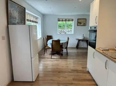 a kitchen and dining room with a table and chairs at Kimberly House in Arthog