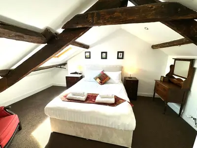 a bedroom with a large bed in a attic at The Bear Apartments in Llandovery