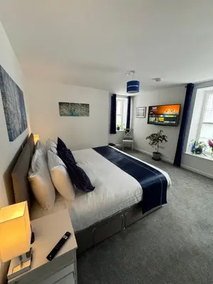 a bedroom with a large bed and a couch at The Bear Apartments in Llandovery