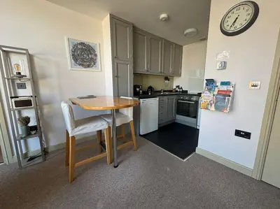 a kitchen with a small table and a refrigerator at The Nook Castle Street Ludlow in Ludlow