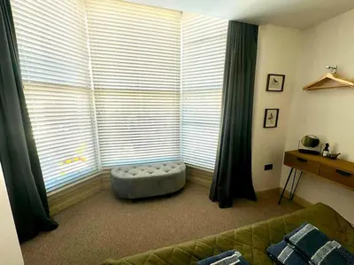 a living room with a large window with a dog bed at The Nook Castle Street Ludlow in Ludlow